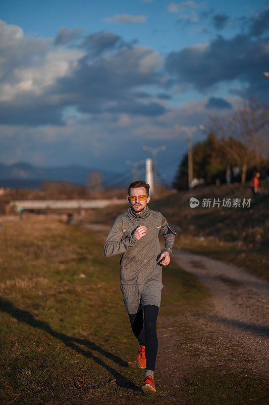 一个在河边锻炼/跑步的年轻人